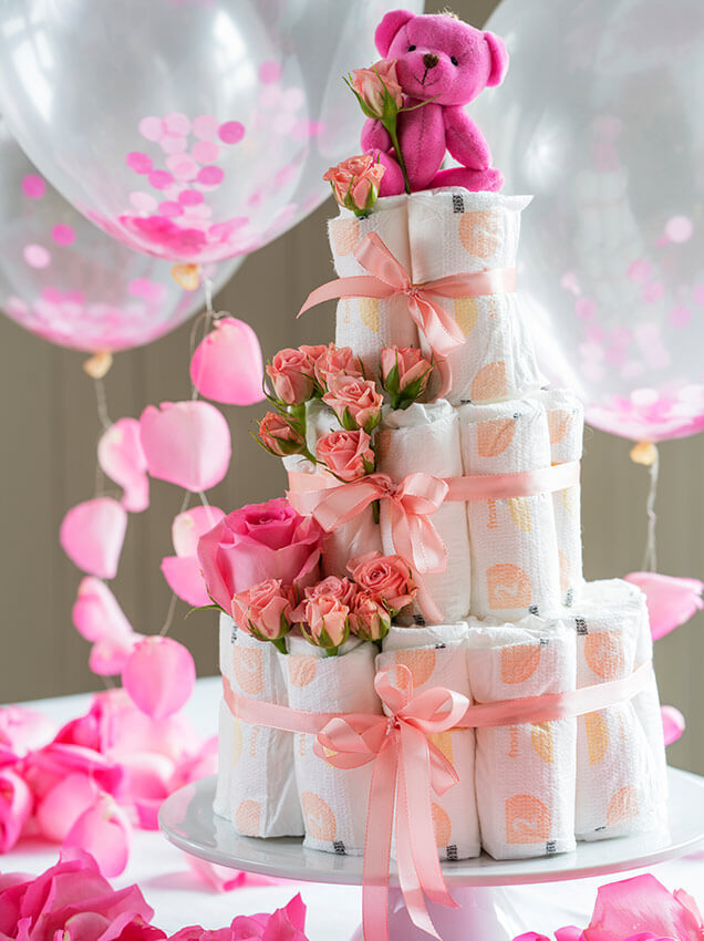 Tårn med bleier og rosa blomster til babyshower