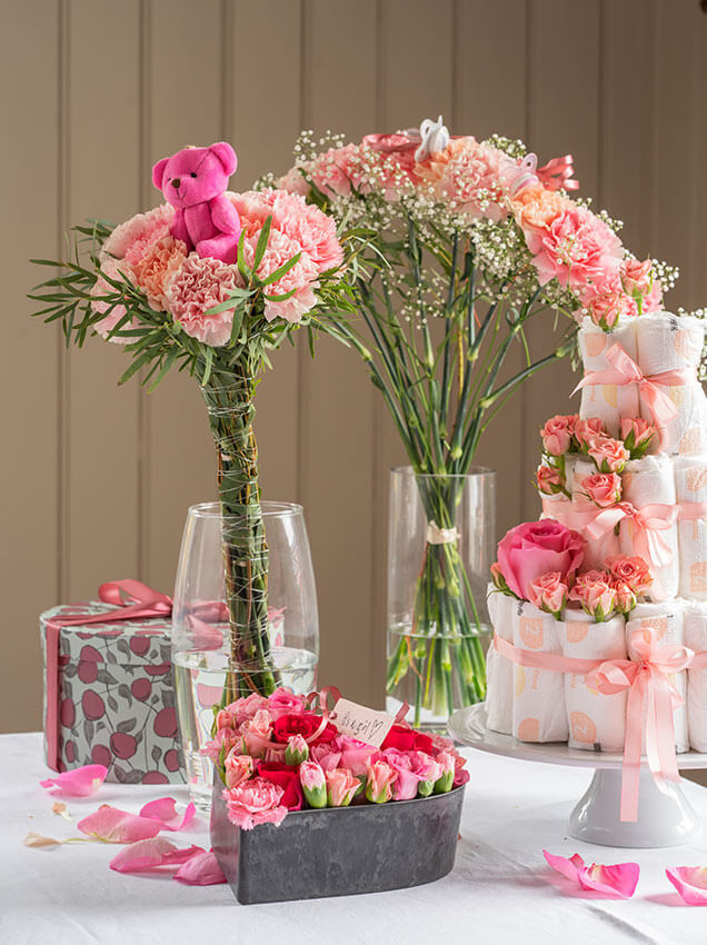 Rosa blomster på bord med gaver