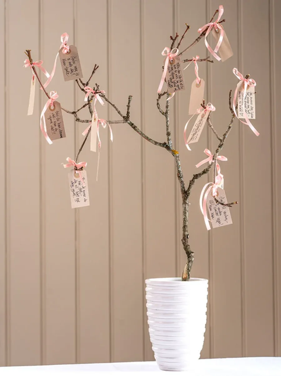 Et lite tre i potte med lapper til babyshower