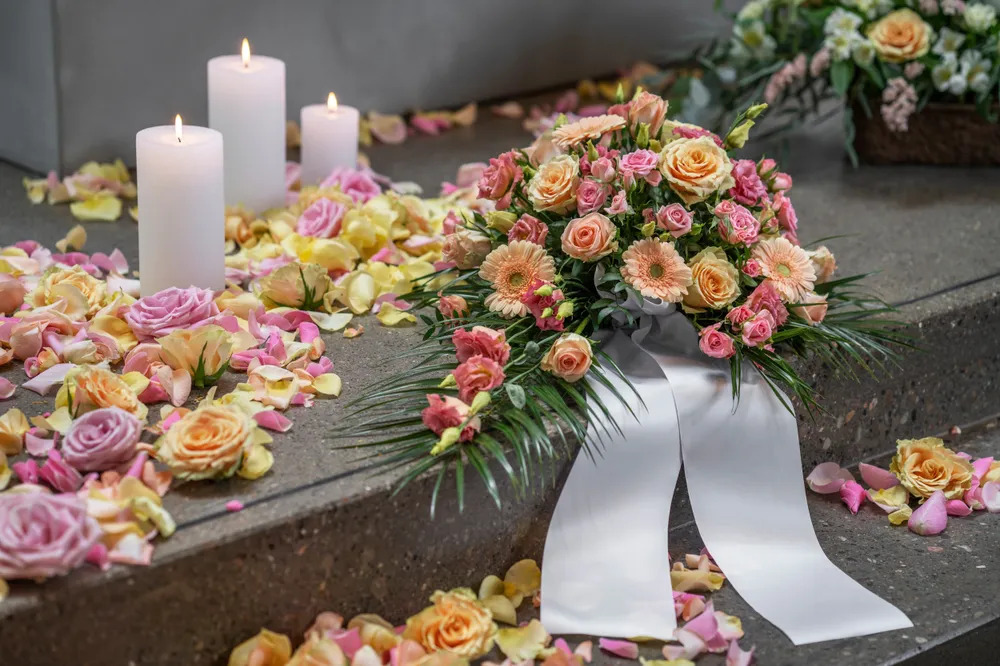Bårebukett i rosa og gult med bånd