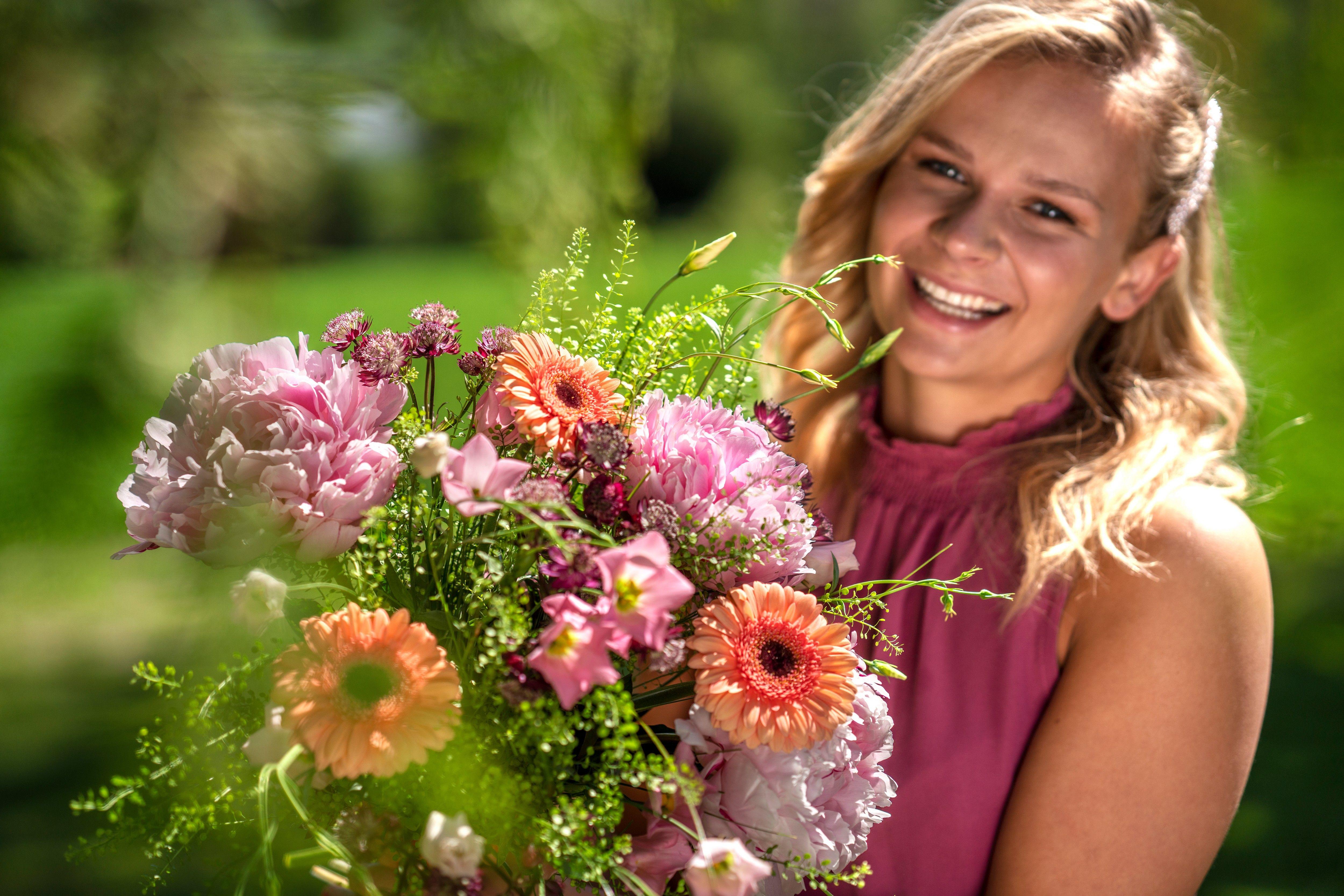 Dame med stor bukett sommerblomster