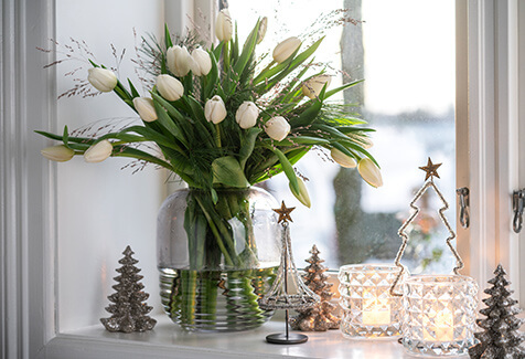 Hvite tulipaner og julepynt i vindu